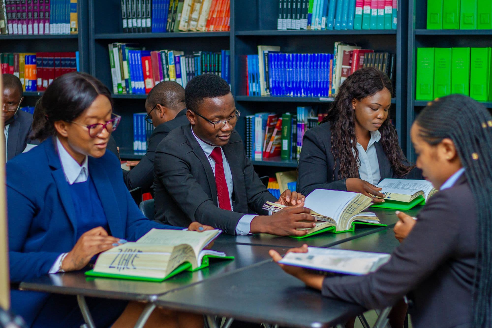 A study group working through books together around a library table